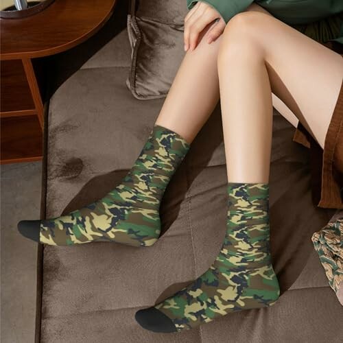 Person wearing camo print socks sitting on a sofa.