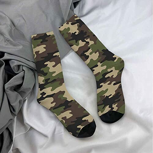 Pair of camouflage socks on gray sheets.