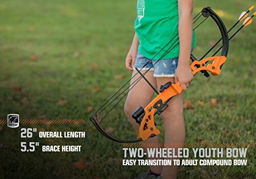 Child holding an orange two-wheeled youth bow on grass.